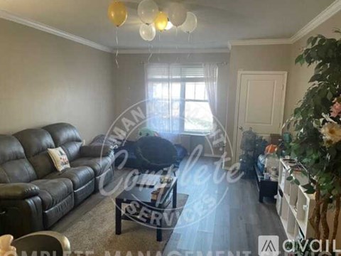 A living room with a black leather sofa and a glass coffee table.