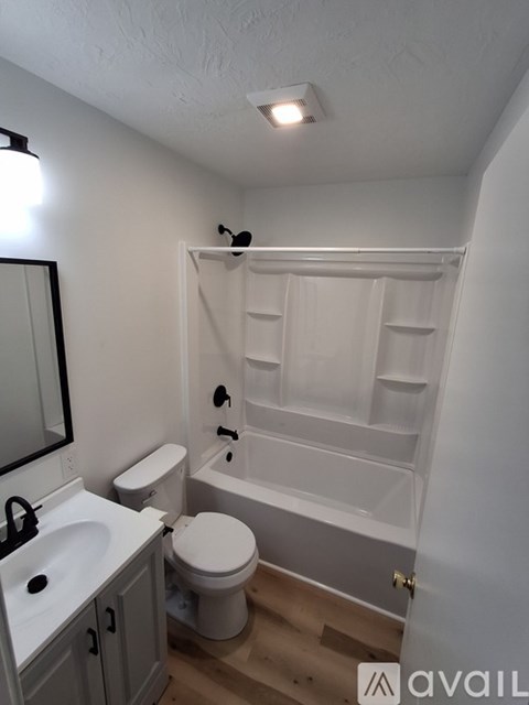 A bathroom with a toilet, sink, and bathtub.