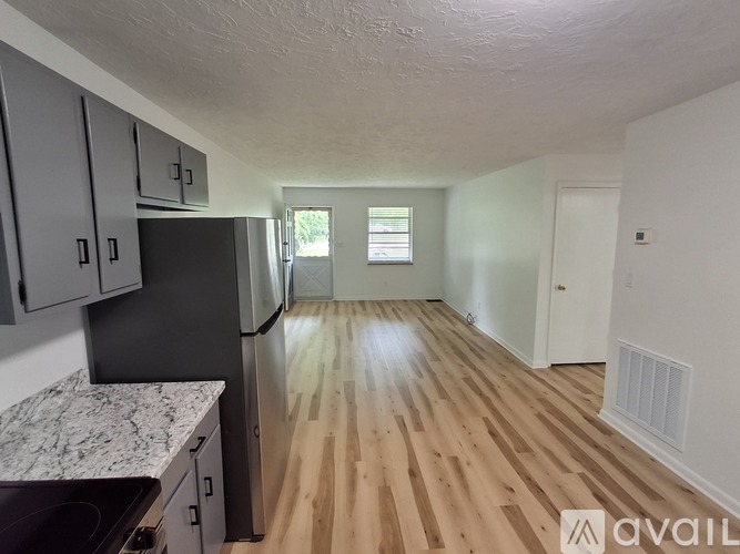 A kitchen with a black refrigerator and a marble countertop.