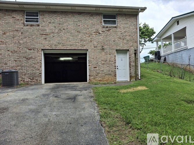 A brick building with a garage door and a white door.