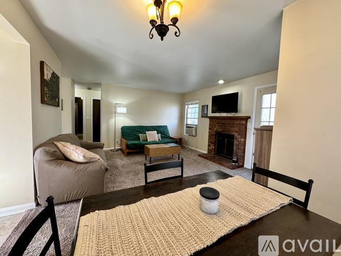 A living room with a couch, chair, and rug.
