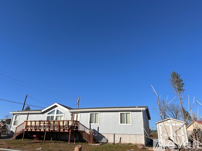 A house with a wooden deck in front of it.