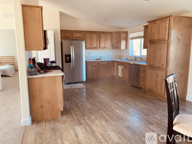 A kitchen with wooden cabinets and a refrigerator.