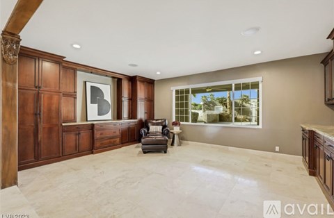 A spacious living room with a large window, a couch, and a painting on the wall.