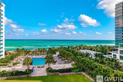A view of a pool and palm trees from a high vantage point.
