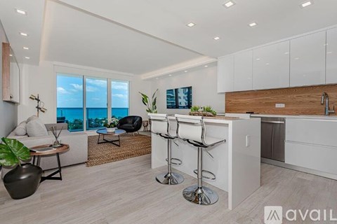 A modern kitchen with white cabinets and a bar area.