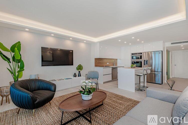 A modern living room with a black chair and a wooden coffee table.