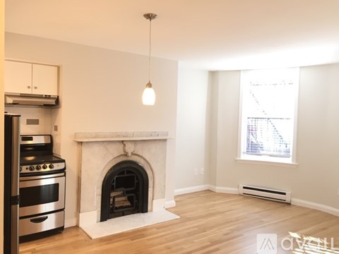 A modern kitchen with a stove, oven, and a fireplace in the living room.