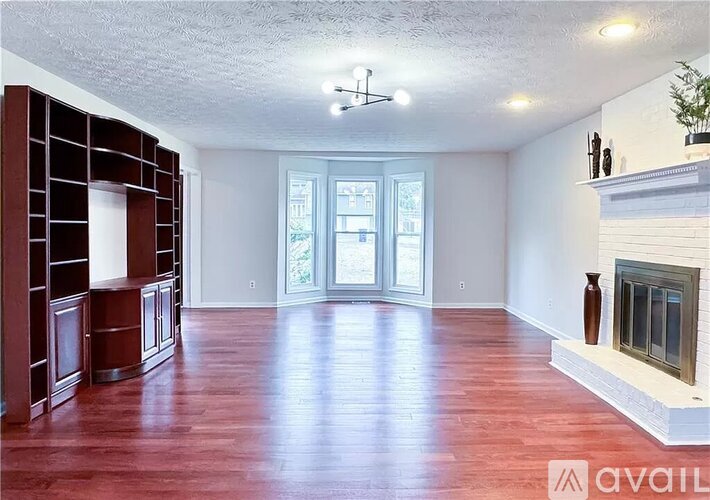A living room with wood floors and a fireplace.