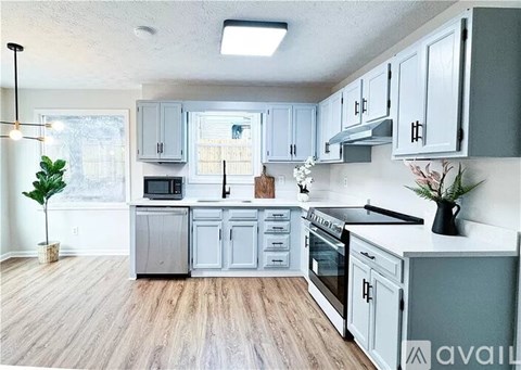 A kitchen with grey cabinets and a wooden floor.