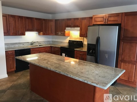 A kitchen with brown cabinets and a granite countertop.