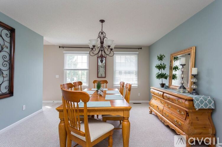 A dining room with a wooden table and chairs.