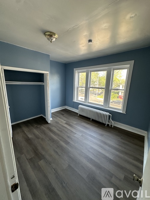 A room with blue walls and a window with a white frame.