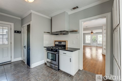 A kitchen with a stove top oven and a range hood.