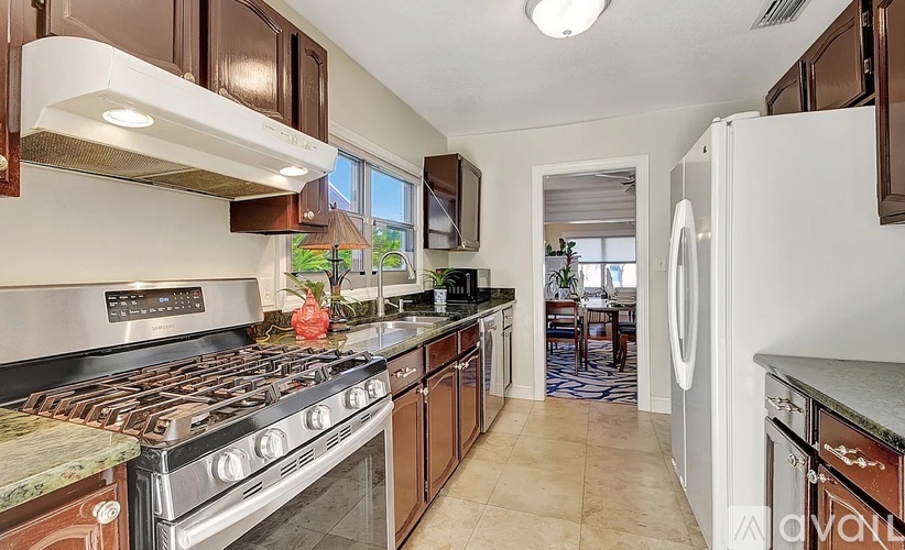 A kitchen with a stove top oven and a refrigerator.