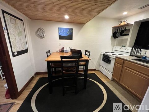 A kitchen with a table and chairs in the middle of a rug.