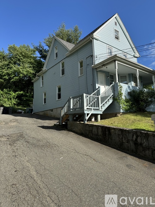 A house with a blue exterior and a white porch.