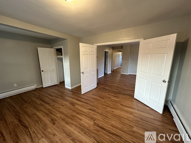 A room with wooden floors and white doors.