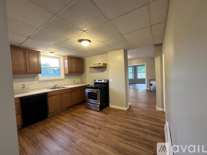 A kitchen with wooden floors and a black dishwasher.