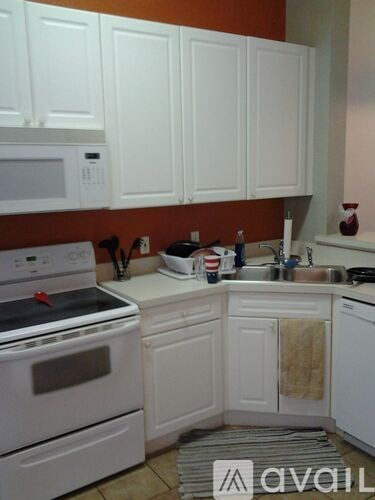 A kitchen with white cabinets and appliances.