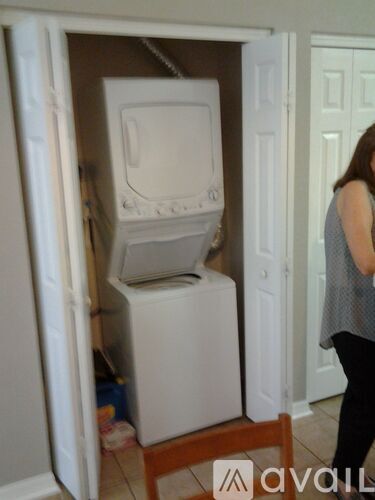 A woman is looking at a stack of white appliances in a doorway.