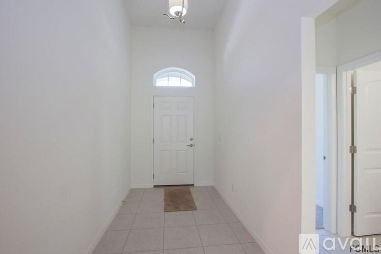 A hallway with a white door and a window.