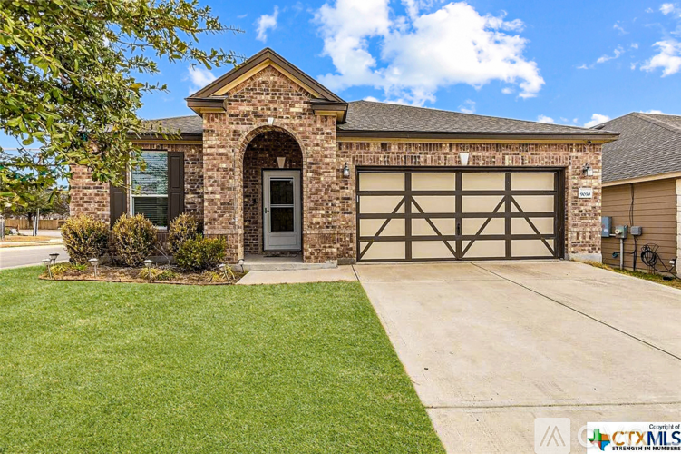 A house with a brick facade and a large garage door.