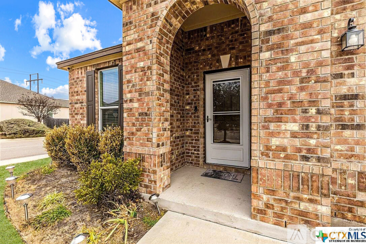 A house with a brick archway entrance and a white door.