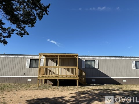 A wooden deck structure is in the foreground with a building in the background.