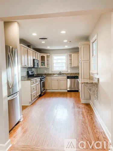 A kitchen with wooden floors and white cabinets.