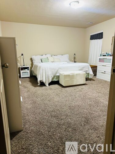 A bedroom with a bed, nightstand, and a microwave.
