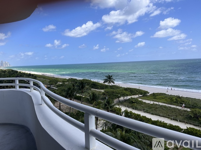 A view from a balcony overlooking a beach with a clear blue sky.