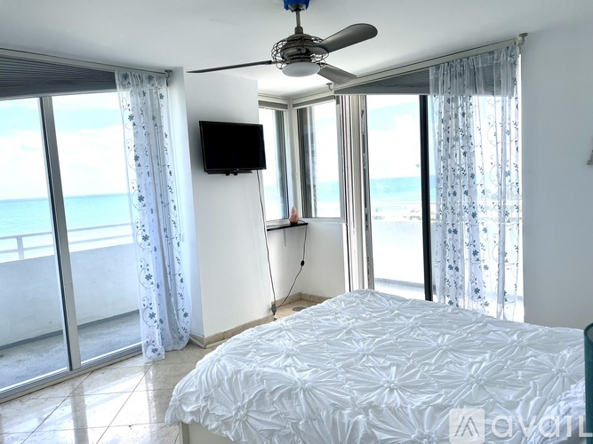 A bedroom with a large bed and a flat screen TV mounted on the wall.