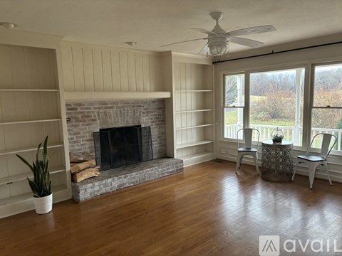 A living room with a fireplace and a ceiling fan.