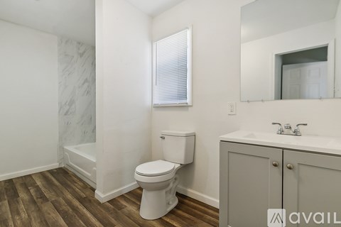 A bathroom with a toilet, sink, and mirror.