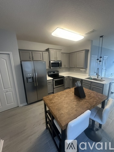 A kitchen with a table and chairs in the foreground.