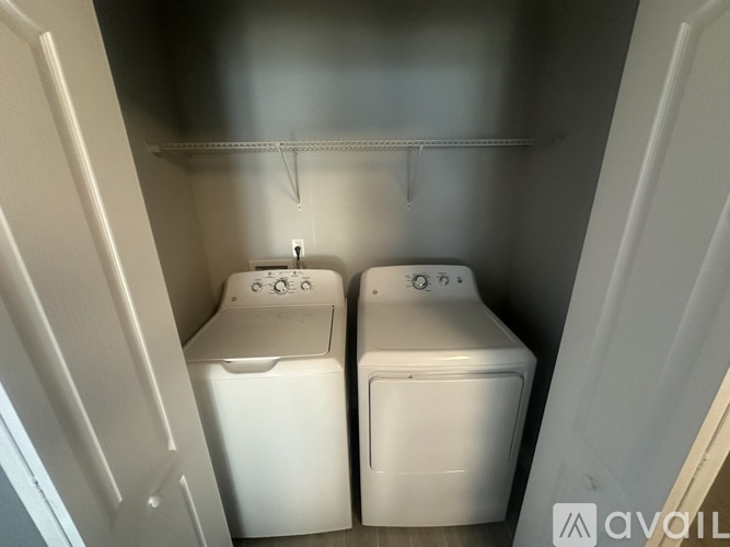 Two white washing machines in a small laundry room.