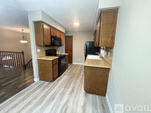 A kitchen with wooden cabinets and appliances is available for rent.