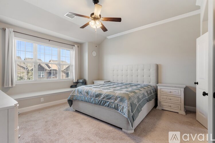 A bedroom with a bed, dresser, and window.