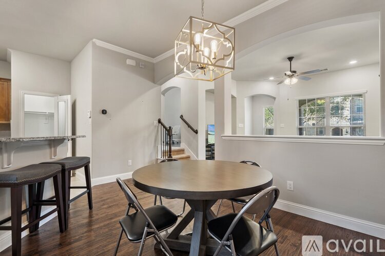 A dining room with a round table and chairs.