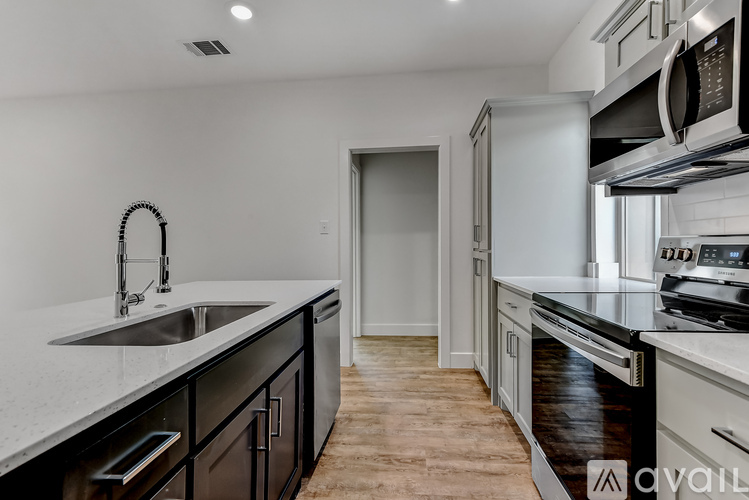 A modern kitchen with a sink, stove, and cabinets.