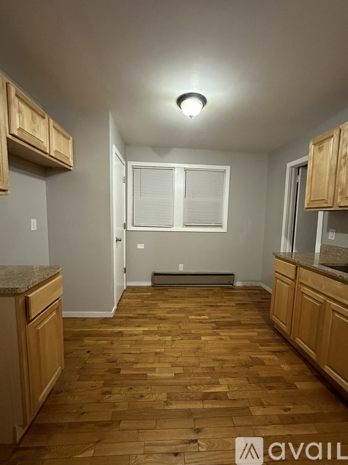 A kitchen with wooden floors and cabinets.