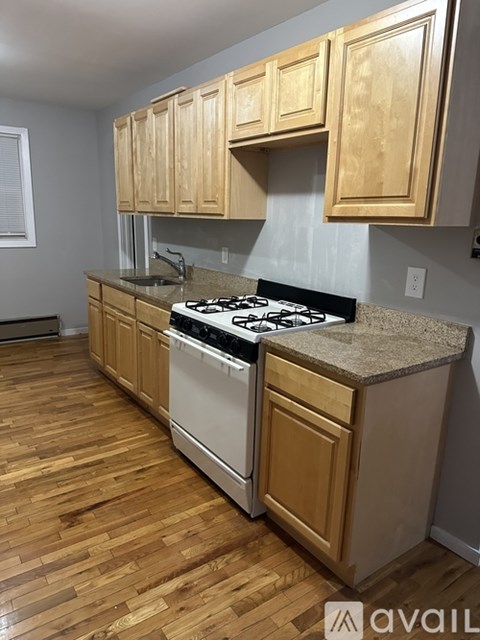 A kitchen with wooden cabinets and a white stove top oven.