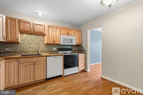 A kitchen with wooden cabinets and a tiled backsplash.