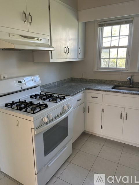 A white stove and oven in a kitchen with white cabinets.