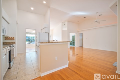 A spacious kitchen with white cabinets and a wooden island.