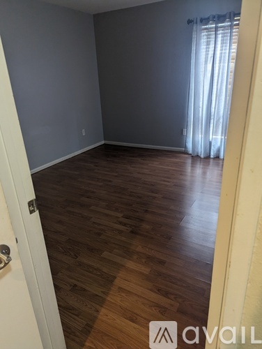 A room with wooden flooring and a white door.