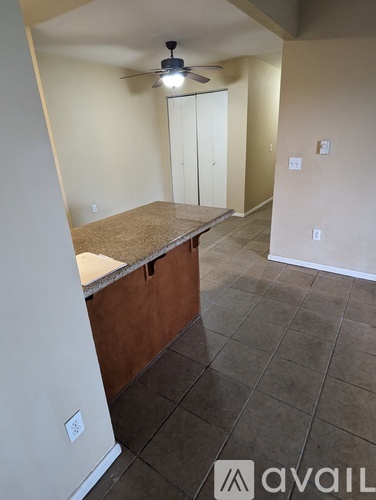 A room with a ceiling fan and a counter.