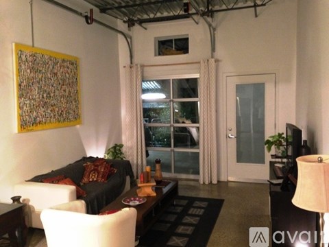 A living room with a couch, chairs, and a painting on the wall.