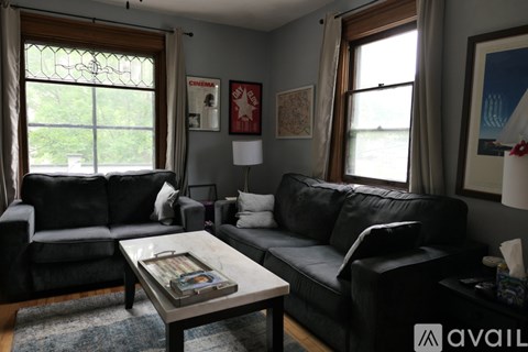 A living room with two black leather couches and a coffee table.